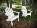 Enjoy a lazy day on these recycled plastic lumber-made Adirondack chairs. White Adirondacks